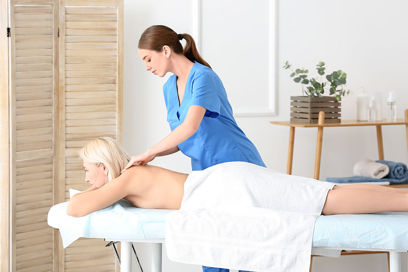 Fotografia fizjoterapeutki przeprowadzającej zabieg masażu terapeutycznego